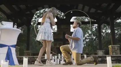 Engagement proposal photographed outdoors at golden hour